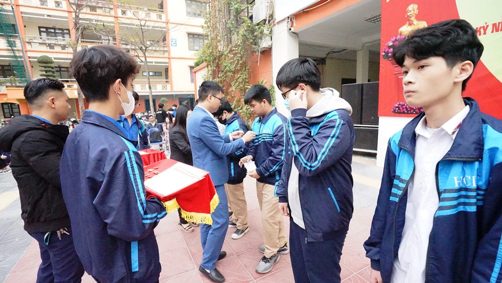 Đ/c Nguyễn Văn Thắng, Trường Phòng CTHSSV-TVVL gắn huy hiệu đoàn cho các đoàn viên mới của trường